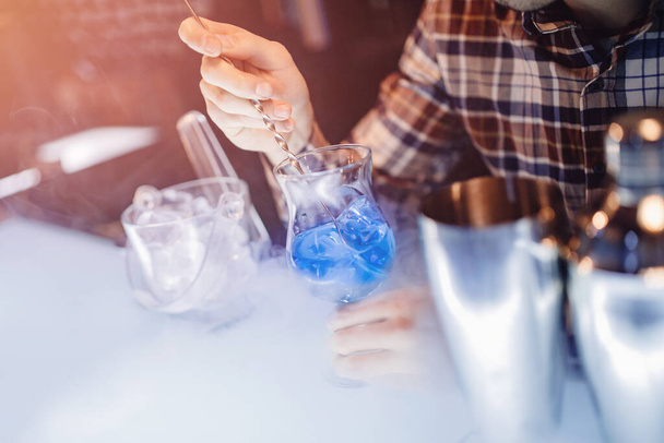 Barman mescola cocktail show blu con bancone bar colorato alcolico e fumo
 - Foto, immagini