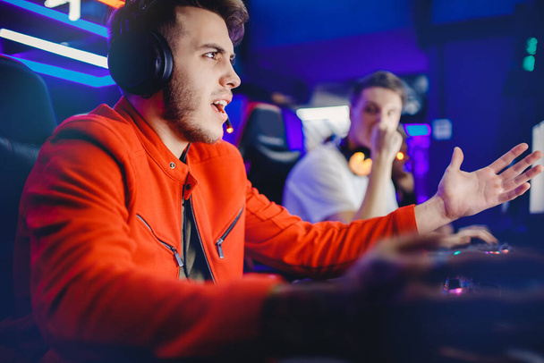 Gamer młody człowiek jest pokonany w gry wideo online, gniew i twarz palmy, krzyki i emocje, neon kolor. Koncepcja uzależnienia od Internetu - Zdjęcie, obraz