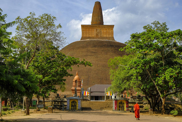 Anuradhapura, Sri Lanka - February 2020:  A monk visiting the Buddhist stupa Abhayagiri Dagoba on February 6, 2020 in Anuradhapura, Sri Lanka. - Fotoğraf, Görsel