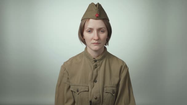 Video of young woman wearing red army uniform on white - Footage, Video
