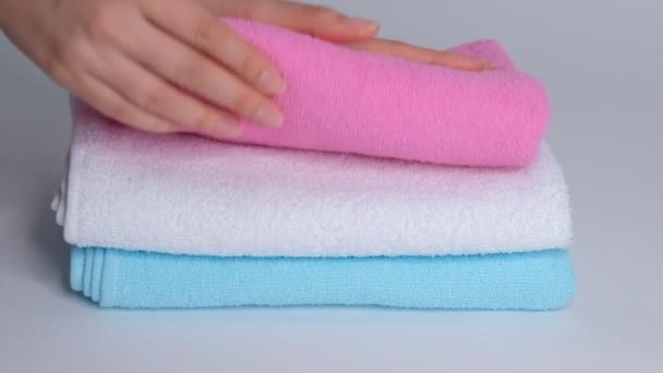 Zbliżenie rąk układających stos świeżych ręczników na prześcieradle. Room service sprzątanie pokoju hotelowego makro - Materiał filmowy, wideo