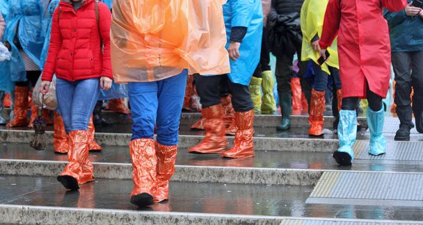 group of people with colored plastics leggings while raining - Foto, afbeelding
