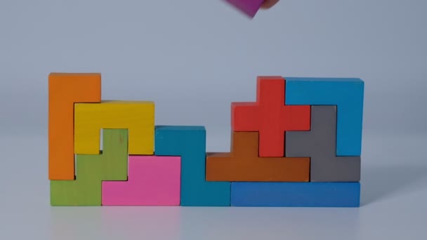 Concept van het onderwijs aan kinderen. Sluiten Slow motion. Een stuk houten blokpuzzel. stapelen van houten blokjes. Concept van complex en slim logisch denken. - Video