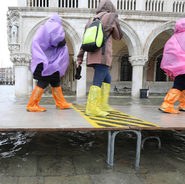 люди ходять по пішохідному мосту у Венеції під час припливу і - Фото, зображення
