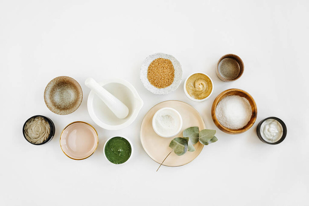 Beauty treatment ingredients for making homemade skin care cosmetic mask. Various bowl with clay, cream, essential oil and natural ingredients  on white table background. Organic spa cosmetic products - Valokuva, kuva