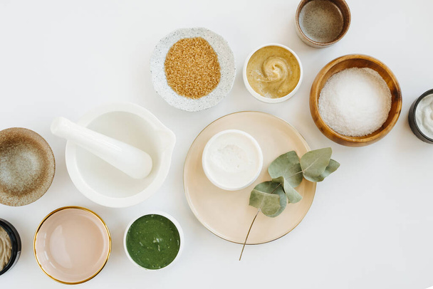 Beauty treatment ingredients for making homemade skin care cosmetic mask. Various bowl with clay, cream, essential oil and natural ingredients  on white table background. Organic spa cosmetic products - Foto, Imagem