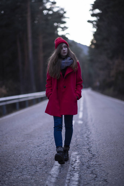 mulher em vermelho pela estrada no inverno - Foto, Imagem