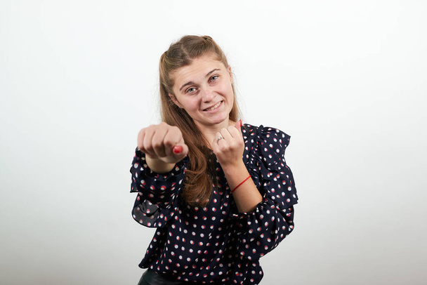 meisje toont haar vuisten in grap bedreigt waarschuwingen - Foto, afbeelding