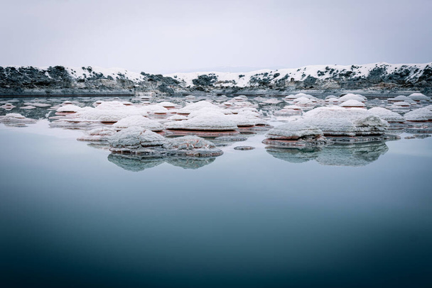 Estanque de embalse de sal con cristales de sal que forman naturalmente en el agua media y salada alrededor después de la lluvia en el lago de Tuz en Turquía
. - Foto, imagen