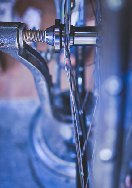 rueda de bicicleta que se comprueba en el soporte y se ajusta en taller de reparación. Herramientas de reparación de bicicletas. Fondo azul
. - Foto, imagen