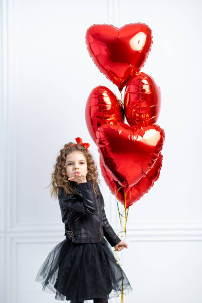 Valentine Beauty young girl, teenager with red air balloon portrait, isolated on white background. Beautiful Happy Young kid holding balloons. Holiday party, birthday. Joyful little model - Fotó, kép