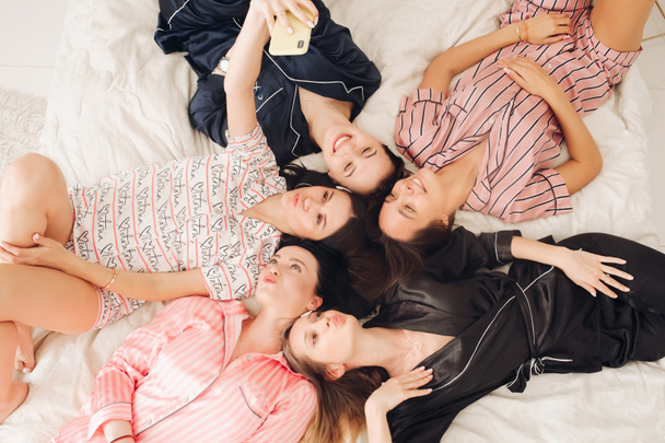Belle ragazze in pigiama prendere selfie sul letto
. - Foto, immagini
