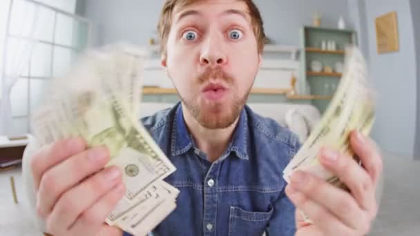 Portré izgatott fiatalember kezében egy csomó pénzt bankjegyek és ünneplő - Felvétel, videó