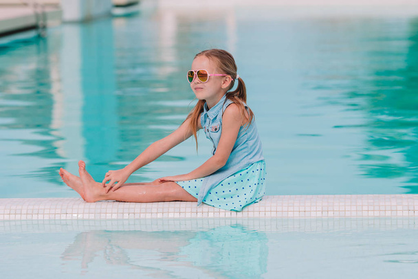Little adorable girl in outdoor swimming pool - 写真・画像