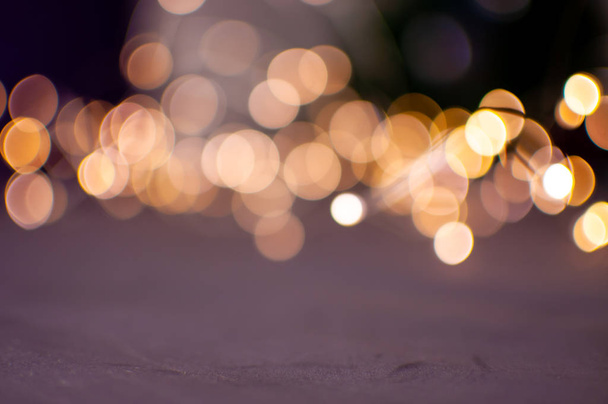 The background is a golden bokeh of the glare of garland lights. Defocus. - Photo, Image