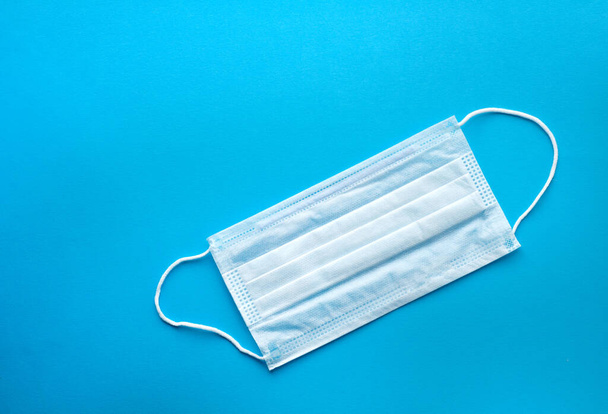 Surgical protective mask on a blue background. Blue medical mask - Фото, зображення