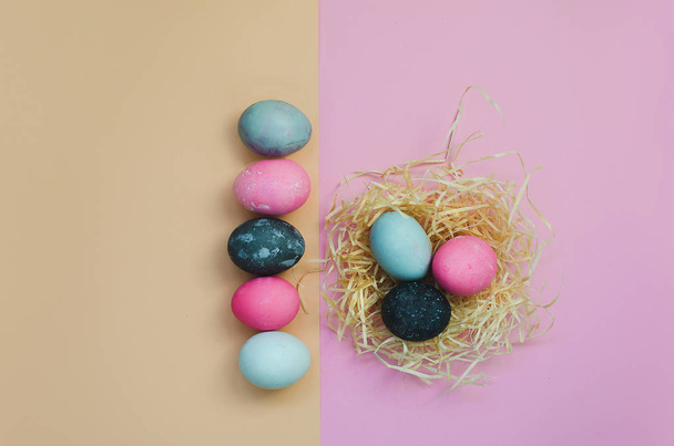 Line of Easter eggs and nestle with eggs on yellow and pink background - Fotoğraf, Görsel