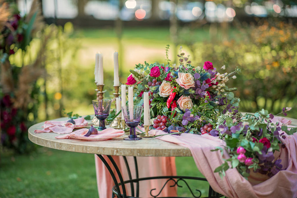 Svatební dekorace na stole květiny svíčky a sklenice - Fotografie, Obrázek