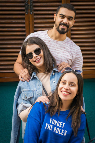 drei glückliche Freunde sind entspannt und posieren mit einem Smiley für ein Gruppenfoto. Fotoshooting mit Familienmitgliedern. - Foto, Bild