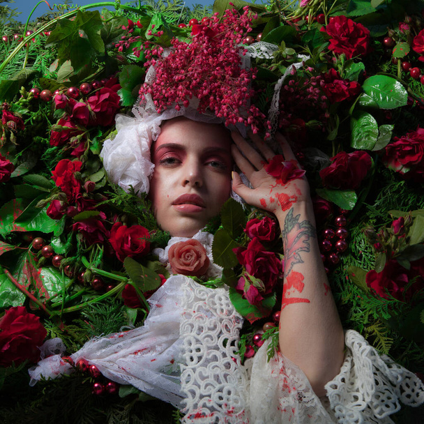 Female portrait in fairy tale stylization surrounded with natural flowers. - Foto, imagen