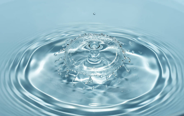 Капли чистой и пресной воды падают с высоты прозрачной голубой воды, образующей брызги в виде оригинальных фигур
 - Фото, изображение