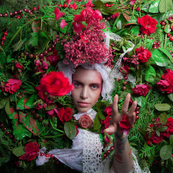 Female portrait in fairy tale stylization surrounded with natural flowers. - Фото, зображення