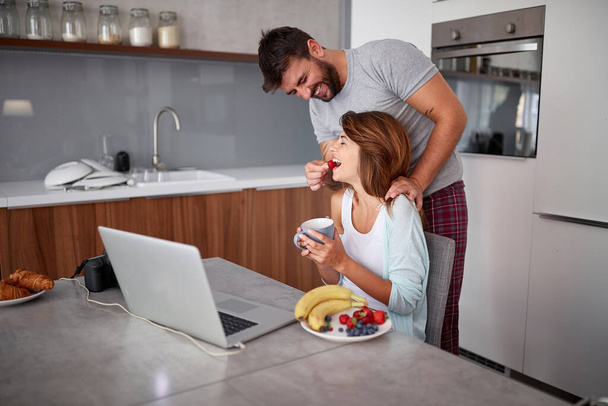 young adult couple having fun while working. A man feeding with  - Photo, Image