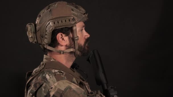 Mężczyzna ubrany w mundur wojskowy obraca się i patrzy w kamerę. - Materiał filmowy, wideo