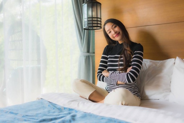 Retrato jovem asiático mulher feliz relaxar sorriso na cama decoração i
 - Foto, Imagem
