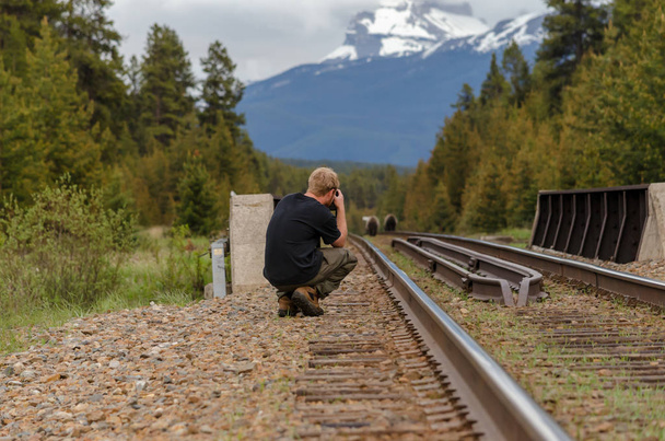 ein Fotograf fotografiert zwei Grizzlybären auf dem Bahngleis - Foto, Bild