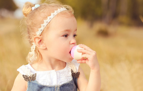 Baby Mädchen essen Cupcake - Foto, Bild