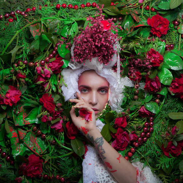 Female portrait in fairy tale stylization surrounded with natural flowers. - Foto, Imagem