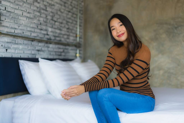 Nuori aasialainen nainen onnellinen hymy rentoutua sängyssä makuuhuoneessa
 - Valokuva, kuva