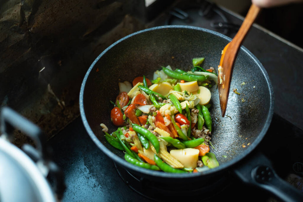 közeli sült zöldségek a serpenyőben a konyhában - Fotó, kép