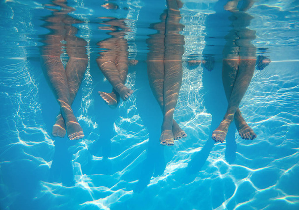 Avvicinamento di amici, gambe di famiglia sott'acqua in piscina
 - Foto, immagini