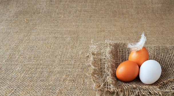 œufs bruns et blancs biologiques de poulet fraîcheur non cuite nutrition sur le lin, sac brun pour la texture de fond. mise au point douce, gros plan, espace de copie
 - Photo, image