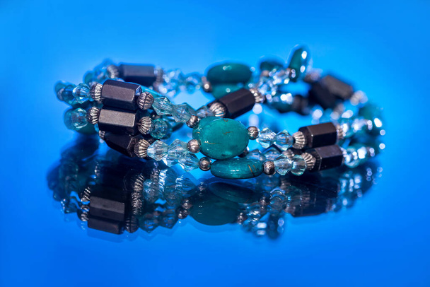 pulsera mezcla piedras preciosas y perlas aisladas en azul oscuro
. - Foto, imagen