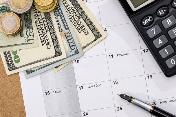 calendar with tax due date and us money, pen, calculator. April 2017. - Фото, изображение