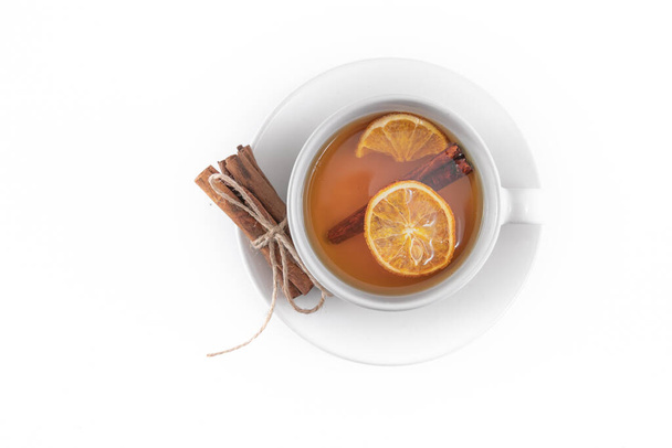 Cup of fruit tea with dry orange and cinnamon isolated on white  - Photo, Image
