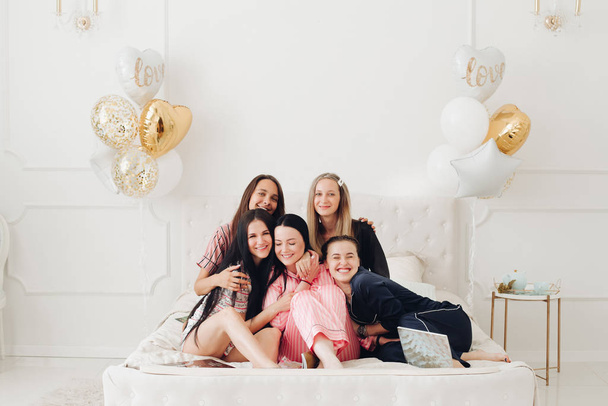 Šťastné krásné kamarádky sedící na kraji postele - Fotografie, Obrázek