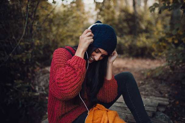 Mladá žena poslouchá hudbu se sluchátky v lese - Fotografie, Obrázek