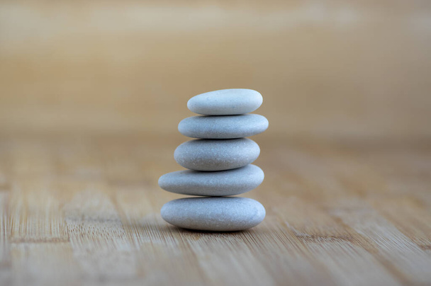 Stone cairn on wooden background, five stones tower, simple poise stones, simplicity harmony and balance, rock zen - Foto, Imagem