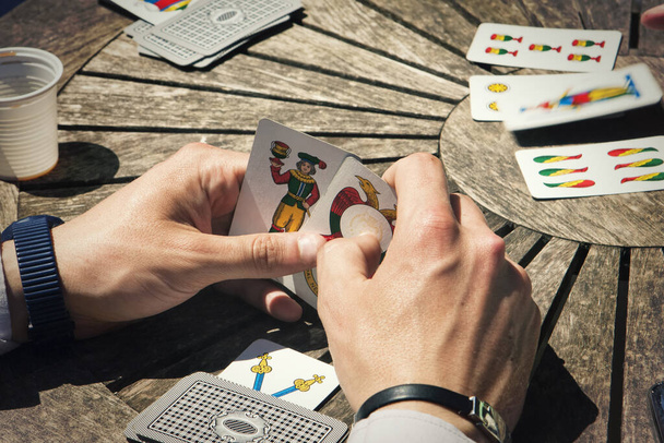 Eerste persoon weergave van de handen spelen Trump kaarten met traditionele  - Foto, afbeelding