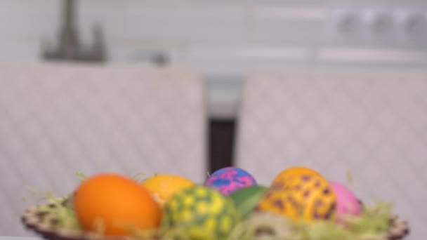Happy easter. A little girl in rabbit ears shows up from behind Easter eggs. Happy family children preparing for Easter. Cute little child girl wearing bunny ears on Easter day - Filmagem, Vídeo