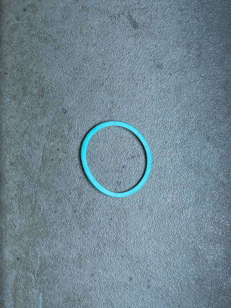 Banda de goma de color sinle sobre un fondo de textura gris
 - Foto, Imagen