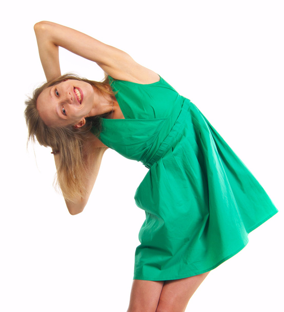 Smiling woman in green dress holding hands behind head - Photo, image