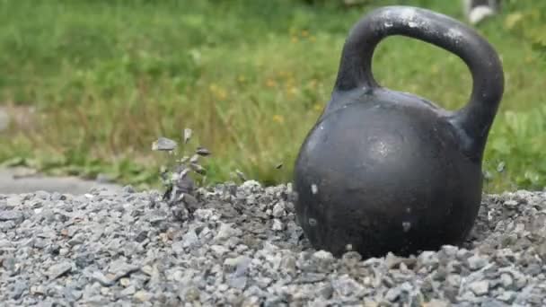 heavy iron kettlebell ανταγωνισμός στην αυλή υπαίθρια fitness έννοια kettlebell πέφτει σε ένα σωρό από πέτρες  - Πλάνα, βίντεο