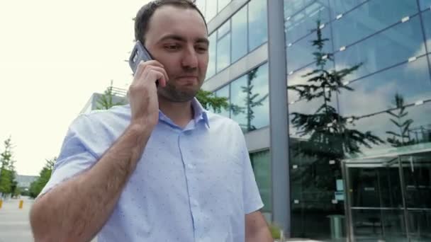 Attractive businessman talking on the mobile phone, feeling happy, hearing good news. - Záběry, video
