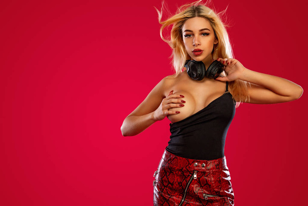 Club poster for night party with young sporty and beautiful woman DJ with headphones isolated on red background. - Foto, immagini