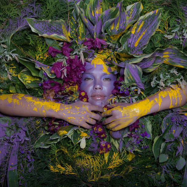 Female portrait in fairy tale stylisation surrounded with natural plants and flowers. - Foto, afbeelding
